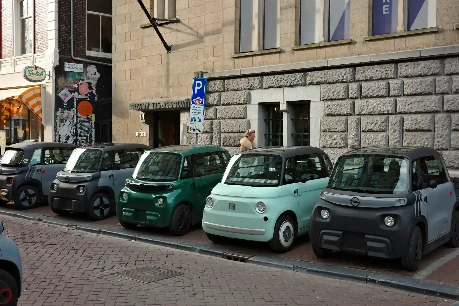 Gruppo di citycar elettriche compatte sotto i 30.000 euro parcheggiate insieme in un piazzale urbano