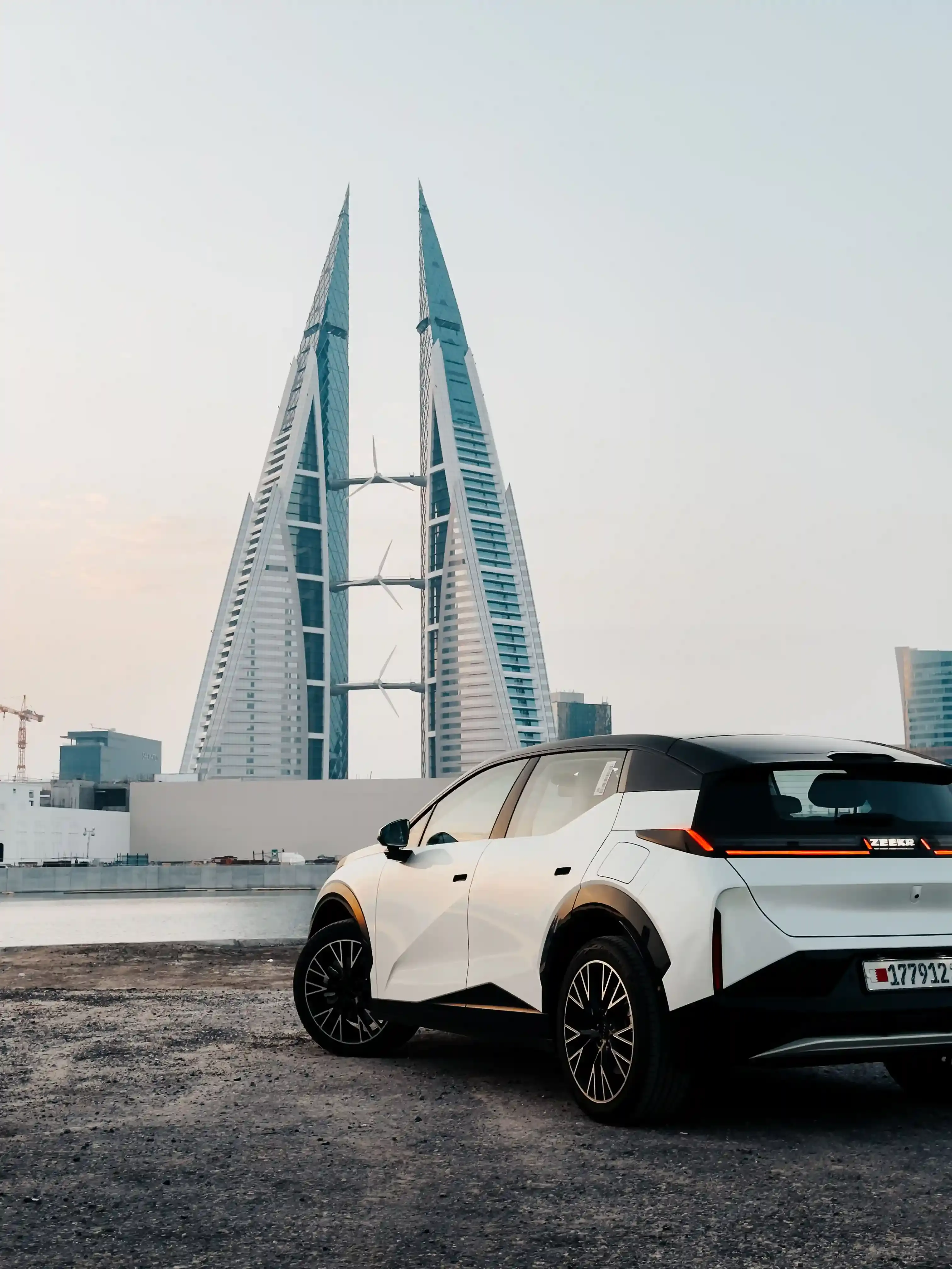 BYD Dolphin azzurra di tre quarti anteriore parcheggiata in città, frontale fluido e cerchi aerodinamici
