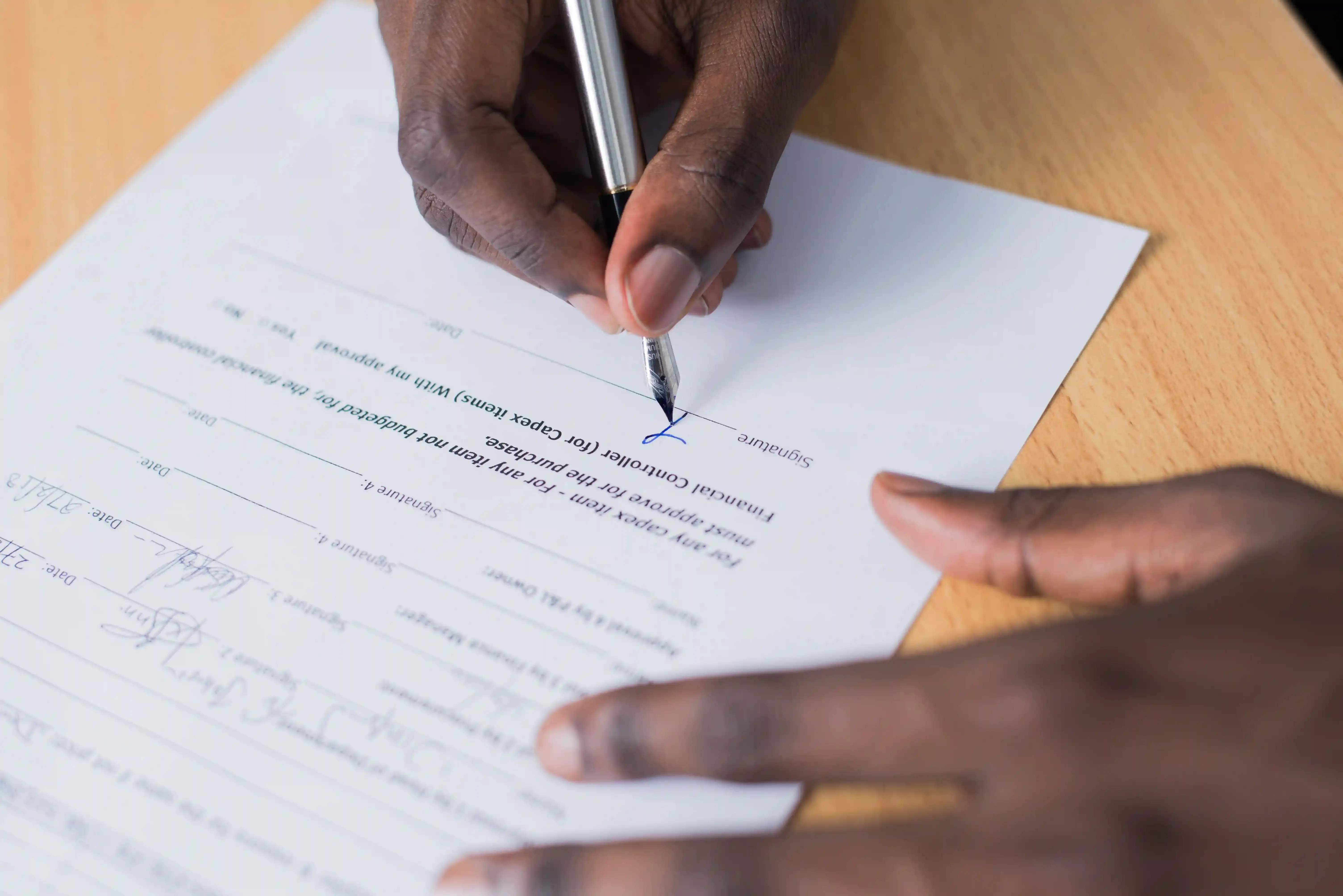 Cliente firma un contratto di finanziamento per un'auto elettrica alla scrivania della concessionaria